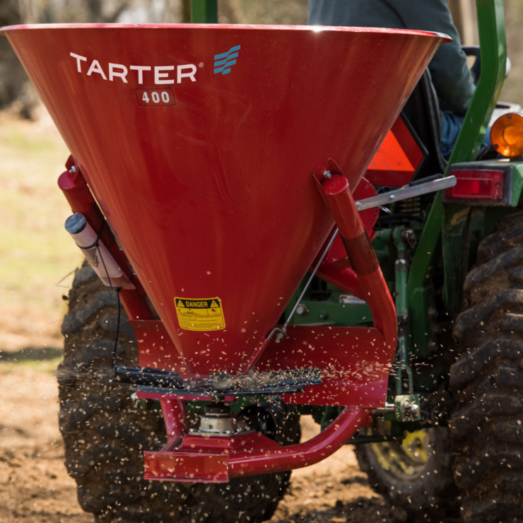 Tarter brand fertilizer spreader at work in field.